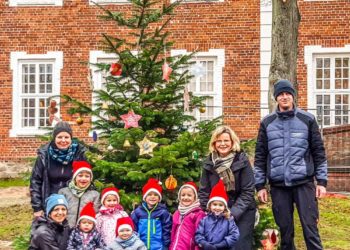 Kindergartenkinder schmücken Weihnachtsbaum