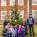 Kindergartenkinder schmücken Weihnachtsbaum